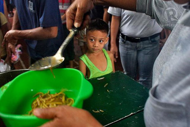 KIND HEARTS. Volunteers feed children evacuees in Malanday Elementary School, Marikina City. Photo by LeANNE Jazul.