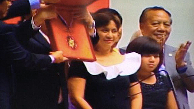 AWARD FOR ROBREDO. House Speaker Feliciano Belmonte Jr holds up the Congressional Medal of Achievement awarded to the late Interior Secretary Jesse Robredo September 12, 2012. Atty Leni Robredo, the widow of the secretary, looks on with their daughter, Jillian. Screengrab from the House feed by Carmela Fonbuena.