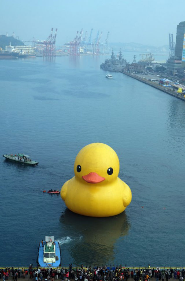 DUCKIE'S BACK! Visitors look at an 18-metre-tall (59-feet) bath toy duck replica created by Dutch artist Florentijn Hofman as it floats in Keelung harbor after its repair. AFP Photo