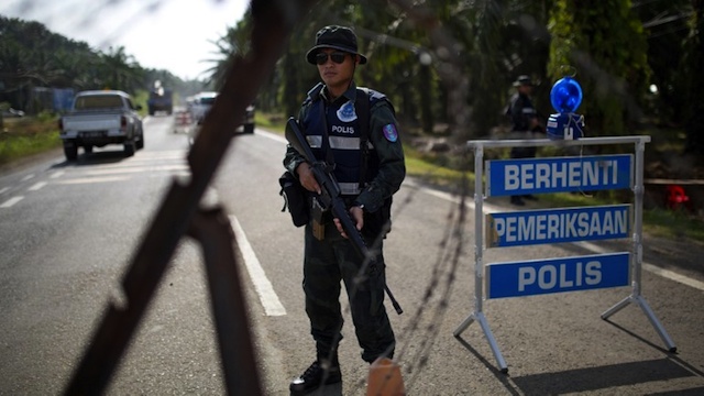 SABAH SIEGE. An armed Malaysian policemen mans a security checkpoint in Lahad Datu on March 6, 2013. AFP PHOTO / MOHD RASFAN