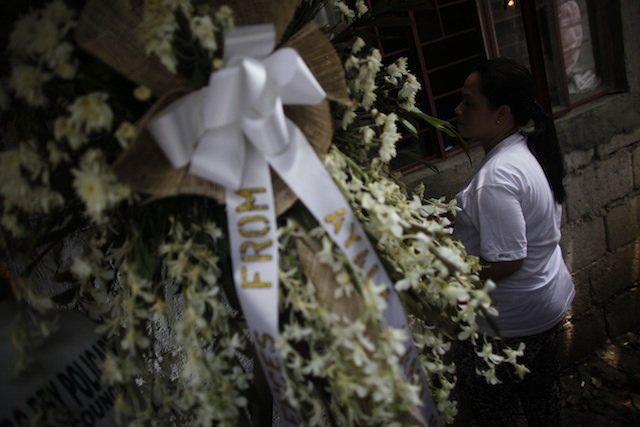 THE WIDOW. Lilibeth Natividad stands watch over her husband's coffin. 9 June 2013.