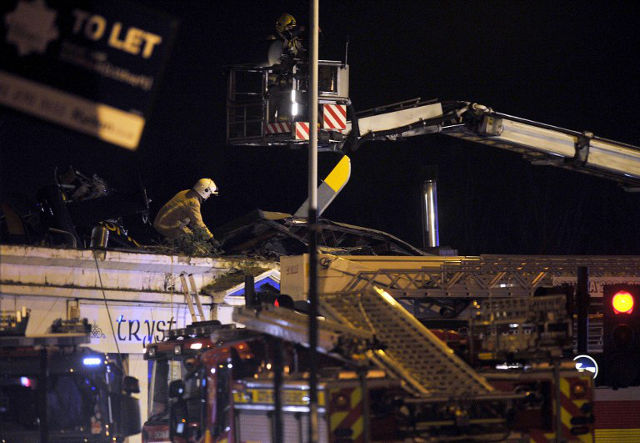 CRASH. Emergency services inspect the roof of a pub where a police helicopter crashed in central Glasgow, Scotland, shortly after midnight on November 30, 2013. ANDY BUCHANAN/AFP PHOTO
