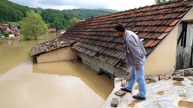 MASSIVE FLOODING. A man looks at the flooded street from the roof of a house in Pozega. Serbia is under a state of emergency due to floods from over 48 hours of rain. Photo by Dragan Karadarevic/EPA