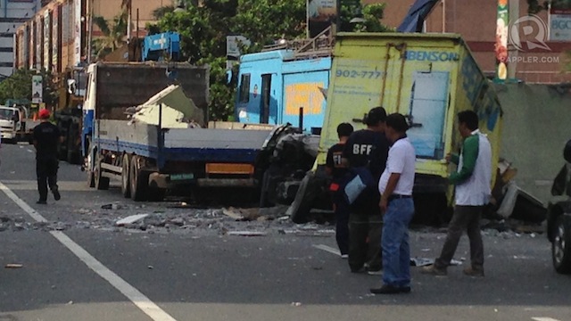 BACK TO NORMAL? MMDA personnel prepared to pull away the truck that was pinned down by a falling wall due to the explosion. 