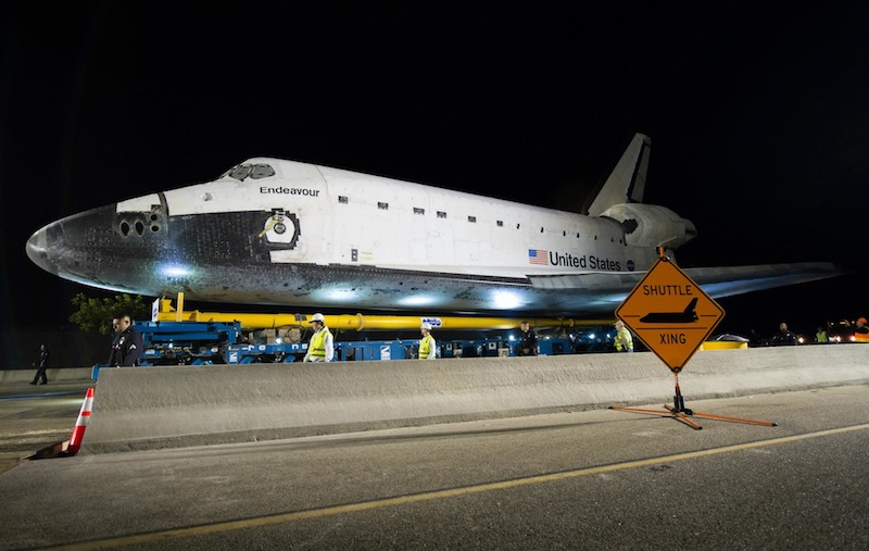 The space shuttle Endeavour is seen atop the Over Land Transporter (OLT) after exiting the Los Angeles International Airport on its way to its new home at the California Science Center in Los Angeles, Friday, Oct. 12, 2012. Endeavour, built as a replacement for space shuttle Challenger, completed 25 missions, spent 299 days in orbit, and orbited Earth 4,671 times while traveling 122,883,151 miles. Beginning Oct. 30, the shuttle will be on display in the CSC’s Samuel Oschin Space Shuttle Endeavour Display Pavilion, embarking on its new mission to commemorate past achievements in space and educate and inspire future generations of explorers. Photo Credit: NASA/Bill Ingalls