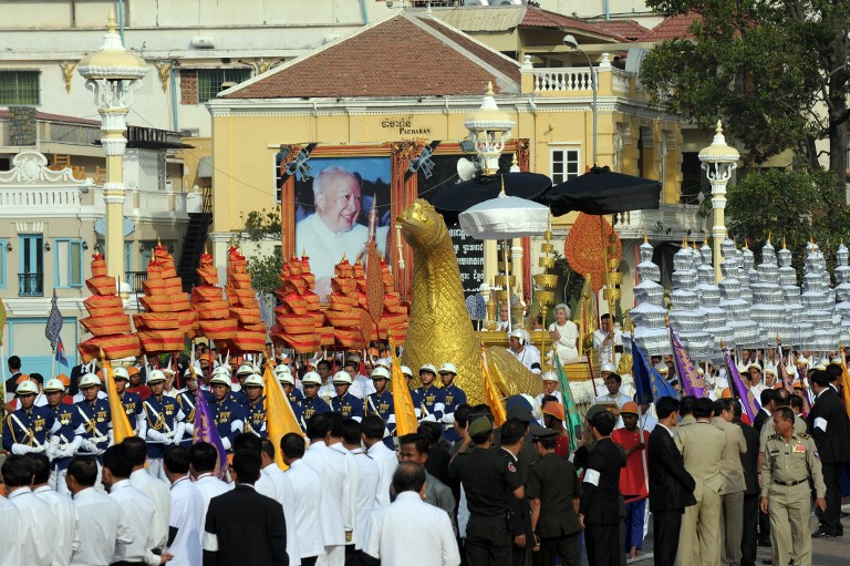 Cambodian royal guard lead a Royal float carries Cambodia's King Norodom Sihamoni, former Queen Monineath and urns loaded with the remains of the late former King Sihanouk from the cremation site near the Royal Palace in Phnom Penh on February 7, 2013 following his cremation on February 4. AFP PHOTO/ TANG CHHIN SOTHY 