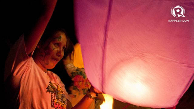 READY FOR FLIGHT. A woman holds a lantern upright before releasing it to the sky. All photos by Katerina Francisco