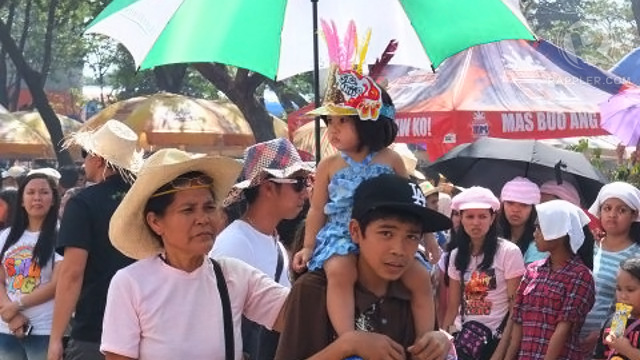 A LITTLE GIRL refuses to miss the festivities, even donning a hat for the occasion