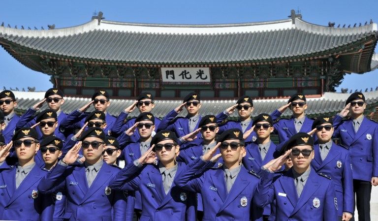 'GANGNAM POLICE.' South Korean "tourist police" officers salute during their inauguration ceremony at Gwanghwamun square in Seoul on October 16, 2013. AFP / Jung Yeon-je