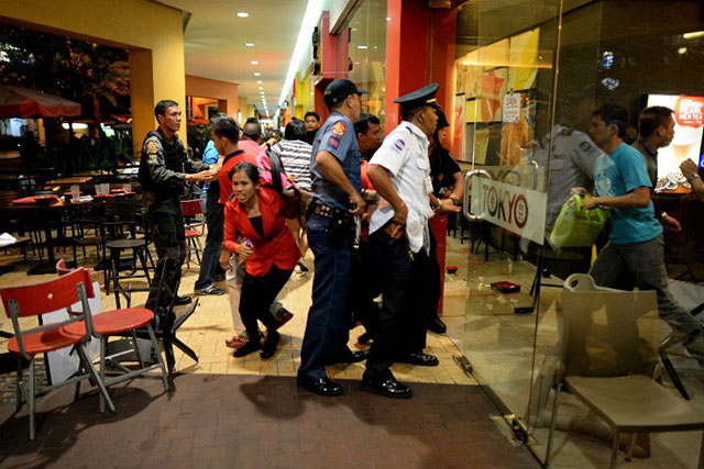 PANIC. Diners rush from a restaurant as a security officer and members of the PNP-SAF moves towards the scene of an attempted robbery on a jewelry store inside the SM Mall of Asia on Sunday, March 30. Photo by Noel Celis/AFP