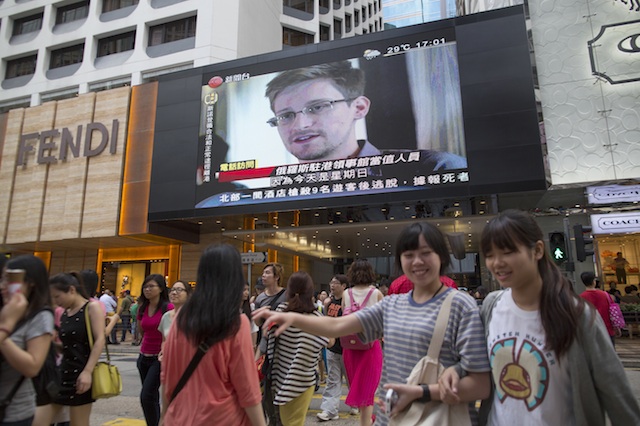LOOMING LARGE. Archive footage of US whistle-blower Edward Snowden is displayed on a giant screen during a local news program in Hong Kong, China, 23 June 2013. Photo by EPA/Jerome Favre
