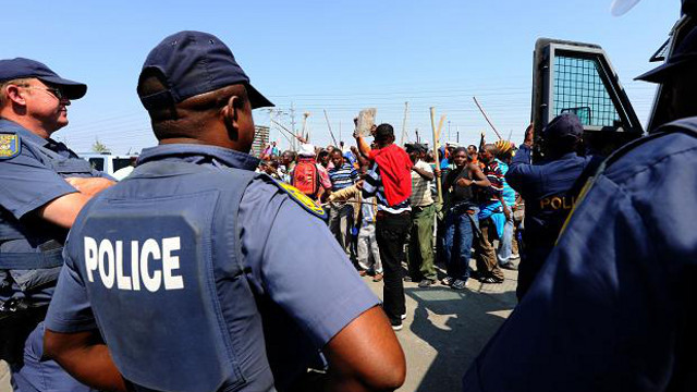 SECURITY. South African police stand guard before striking workers. Photo from AFP