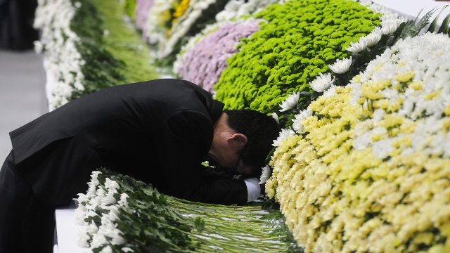 GRIEF AND LOSS. A grief-fuelled moment for a father of a victim of the Sewol ferry accident, at a joint incense-burning altar set up at Ansan Olympic Memorial Hall in Ansan, south of Seoul, South Korea. 23 April 2014. Yang Ji-Woong/EPA