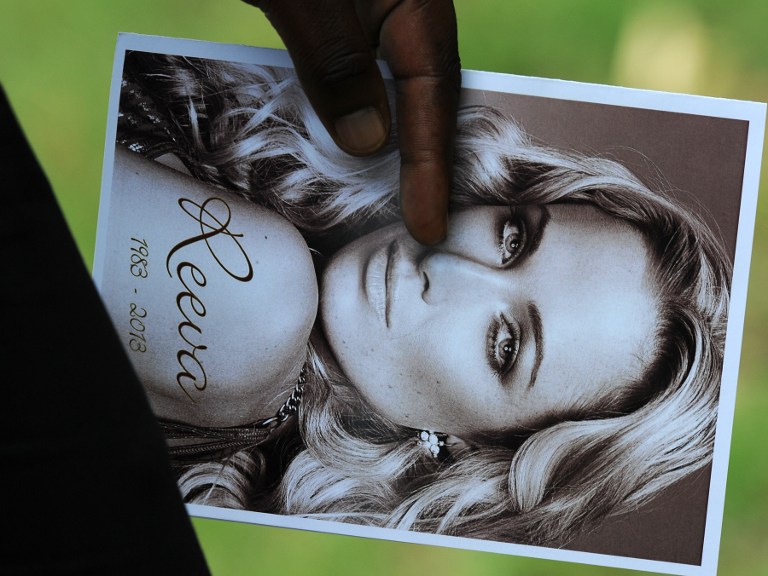 A relative of the late South African model Reeva Steenkamp holds the funeral ceremony program at the crematorium building in Port Elizabeth on February 19, 2013 after Steenkamp, 29, was shot four times in the early hours of February 14, 2013 by a 9mm pistol owned by South African sporting hero Oscar Pistorius. AFP PHOTO / ALEXANDER JOE