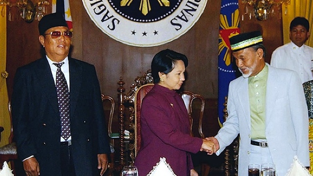 HEIR TO THE THRONE. President Gloria Macapagal-Arroyo (C) shakes hands with Sultan Esmail Kiram (R) while Sultan Jamalul Kiram III looks on at left during a meeting in Malacañang on September 18, 2002. AFP PHOTO/MALACANANG PALACE