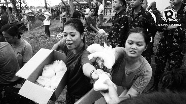 RELIEF. Female soldiers assist evacuees from Tacloban City who arrived at the Mactan airport in Cebu. Photo by Jake Verzosa
