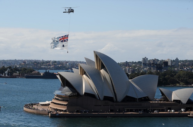 TURNING 40. A Royal Australian Navy Seahawk helicopter flies the Royal Australian Navy ensign flag over the Sydney Opera House as warships sail into Sydney Harbour as part of the International Fleet Review in Sydney, Australia, 04 October 2013. EPA/Dan Himbrechts