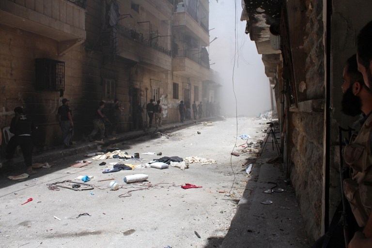 STRIFE-TORN. Syrian rebels gather outside a building which they blew up to target a regime sniper taking shelter inside but who managed to escape in the Salaheddine district of the northern city of Aleppo on July 10, 2013. Photo by AFP/Salah al-Ashkar