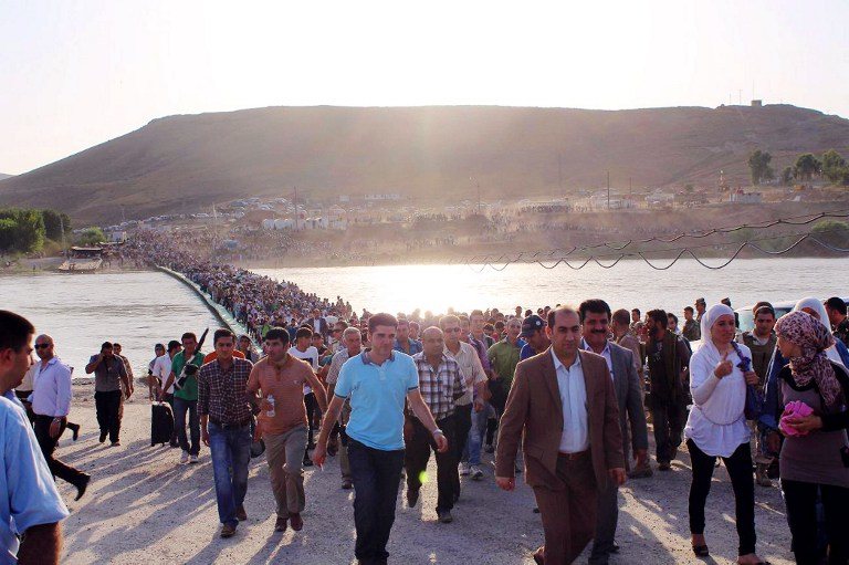 EXODUS. A handout photo obtained from the UNHCR on August 18, 2013 shows thousands of Syrians streaming across a bridge over the Tigris River and entering the autonomous Kurdish region of northern Iraq on August 15. Photo by AFP /  UNHCR / Galiya Gubaeva