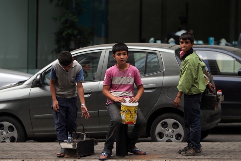 CHILDREN OF WAR. Young Syrian refugees carrying shoe shine kits as they search for customers in a street in Beirut on September 18, 2013. AFP/Joseph Eid