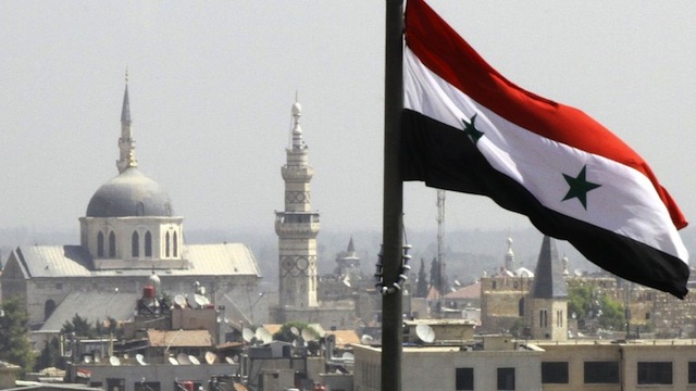 RAGING WAR. The Syrian flag flutters above Damascus on September 20, 2012. AFP PHOTO/LOUAI BESHARA