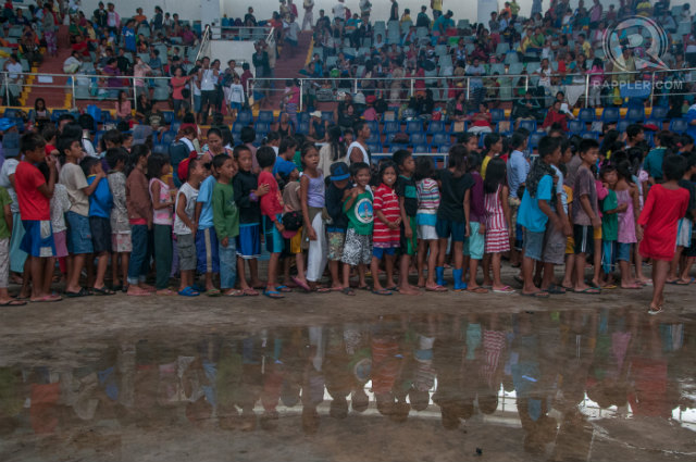 EVACUATING AGAIN. Hundreds of Yolanda (Haiyan) survivors, who still live in tents, return to the Tacloban Astrodome as Glenda (Rammasun) is set to affect Tacloban City. Photo by Roy Lagarde/Rappler