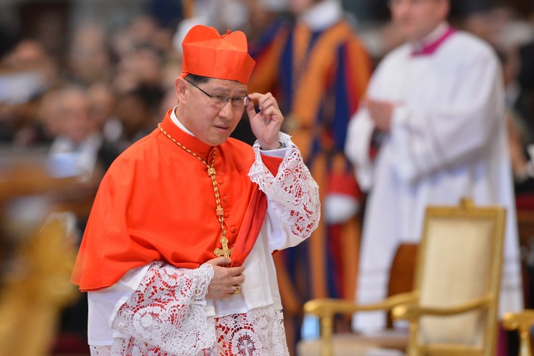 Luis Antonio Tagle of the Philippines walks, wearing his biretta hat, after Pope Benedict XVI appointed him as a cardinal during a ceremony on November 24, 2012 at St Peter's basilica at the Vatican. AFP PHOTO / VINCENZO PINTO
