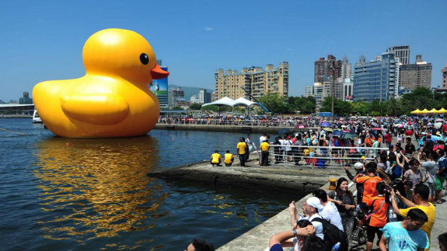 BYE BYE DUCKIE. This handout photograph taken and released by The Kaohsiung City Government on September shows local residents gathering to see Dutch artist Florentijn Hofman's yellow rubber duck (L) at a harbor in the southern city of Kaohsiung. AFP Photo
