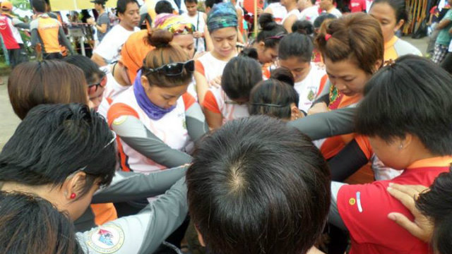 The team prays together before the 2013 Tanauan Dragonboat Race. The author has a purple bandana around her neck. Photo by Jerome de Leon