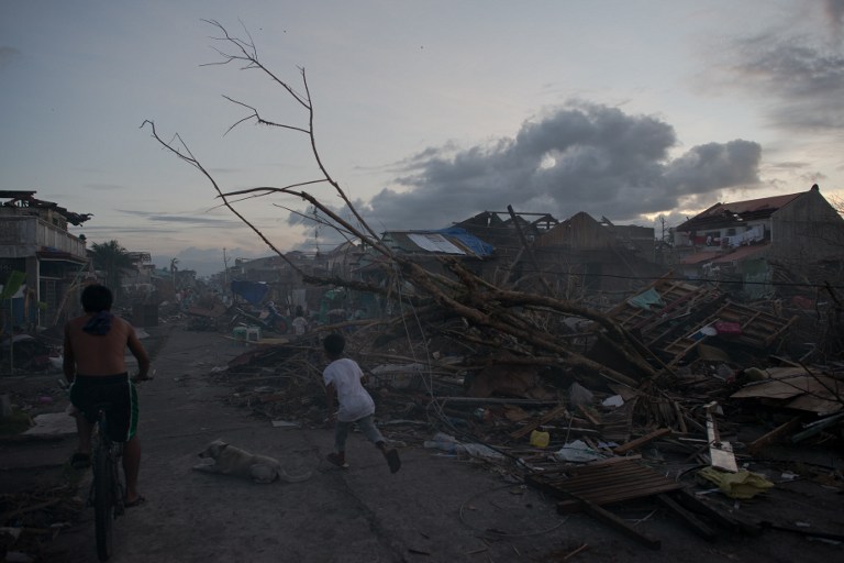 FROM TOWN TO WASTELAND. This picture taken on November 16, 2013 shows typhoon victims outside their destroyed houses in Tanauan on the outskirts of Tacloban. AFP/ Nicolas Asfouri