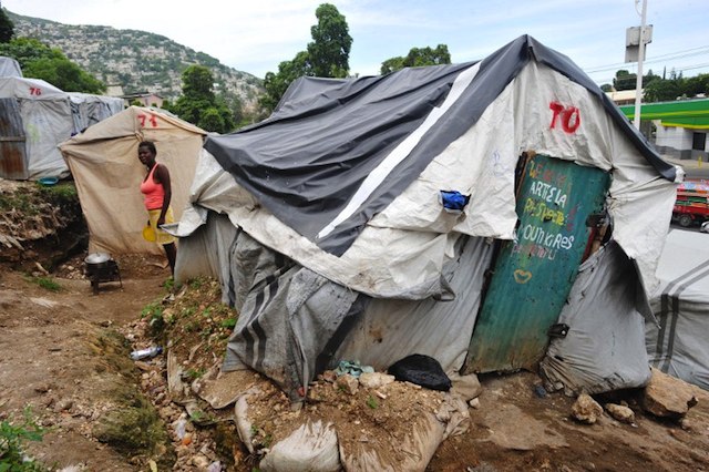 STILL IN TENTS. A young woman prepares food on November 1, 2013 at camp Acra in Pétion-ville, Haiti, where victims of the January 2010 earthquake are living in makeshift tents. AFP/Louis-Joseph Olivier