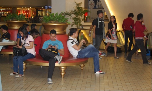 TEXTING CAPITAL. Pinoys busy with their cell phones at Trinoma Mall in the Philippines. Photo by Raymond Virata
