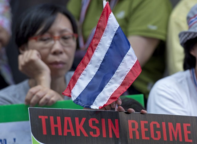 NO RED, NO YELLOW. Thai anti-government protesters hold placards and a Thai flag during a rally in a business district of Bangkok on January 6, 2014. Pornchai Kittiwongsakul/AFP Photo