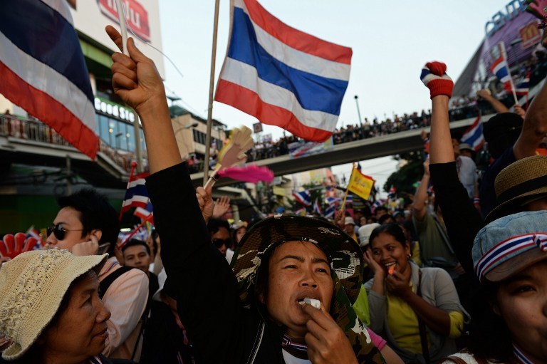 UNREST IN BANGKOK. Thai anti-government protesters wave national flags and blow whistles as they rally at Victory Monument in Bangkok as part of their ongoing rally on December 22, 2013. AFP/Christophe Archambault