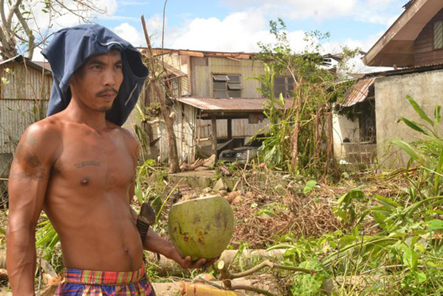 THIRSTY, BUT SURVIVING. Roel Villanoy, 29, a farmer from Poblacion Norte, resorts to coconut water since bottled water has been overpriced. Photo by Julie B. Silvederio, Typhoon Yolanda Story Hub Visayas