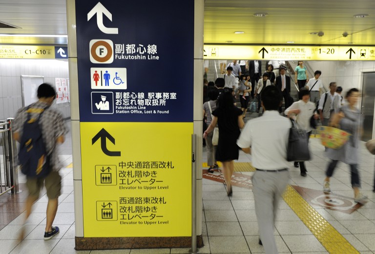RUSH HOUR. This photo taken on July 12, 2013 shows people walking on the concourse to change subways during the morning rush hour at Ikebukuro Station in Tokyo. AFP / Toru Yamanaka