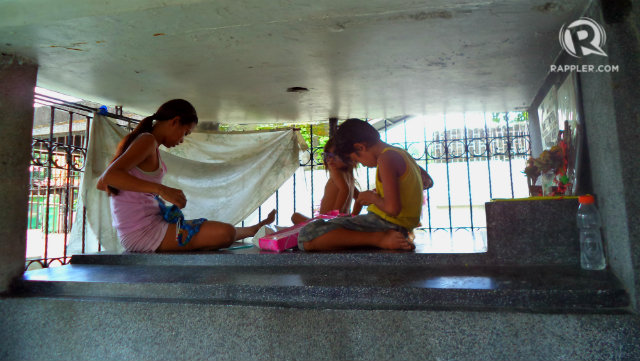 HOME. A mother plays with her 4-year-old daughter and her young nephew. The tomb made of granite serves as their bed. All photos by Fritzie Rodriguez/Rappler.com