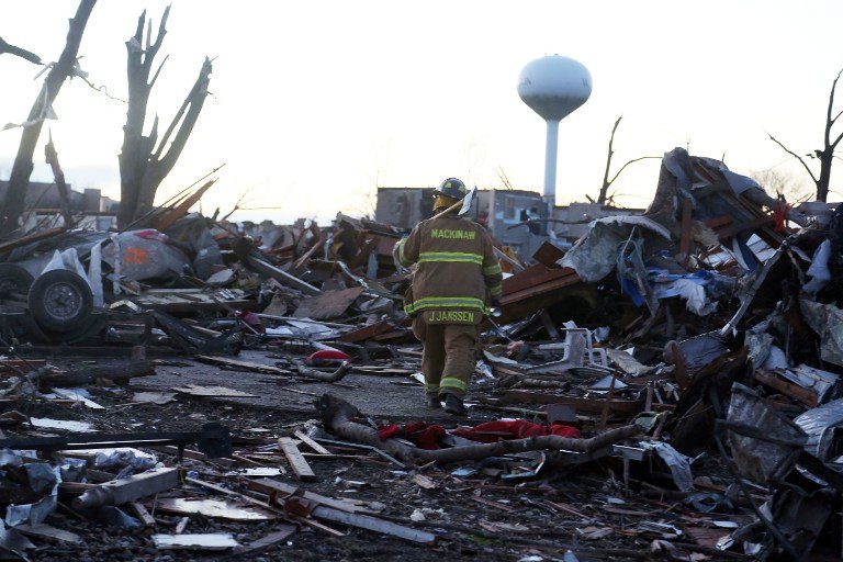 TORNADO AFTERMATH. Jeremy Janssen of Mackinaw Fire Department walks through debris along Elgin Avenue after a tornado struck on November 17, 2013 in Washington, Illinois. Tasos Katopodis/Getty Images/AFP