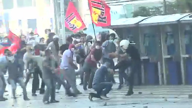 RIOT. Protesters scramble as Turkish police enter Taksim Square throwing tear gas and backed by water cannons. Screengrab from Turkey Youth Union Facebook Page.
