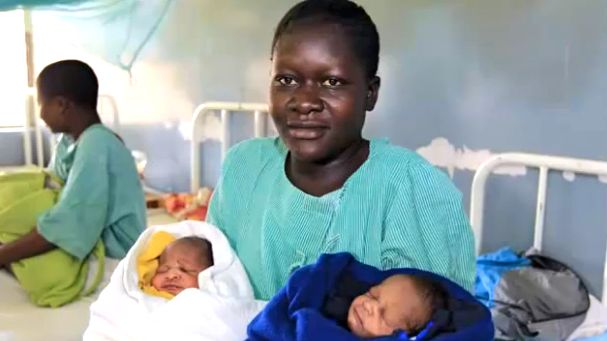 BARACK AND MITT'S MOM. Millicent Awuor with her newborn twins Barack Obama (white) and Mitt Romney (blue). Screen grab from YouTube (NTDTV)