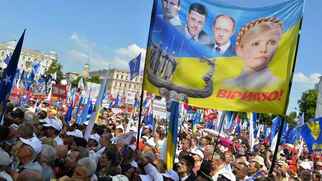 In this file photo, demonstrators hold banners and placards depicting former Ukrainian prime minister Yulia Tymoshenko during an opposition rally "Rise up Ukraine!" in the center of Kiev on May 18, 2013. Photo by AFP/Sergei Supinsky