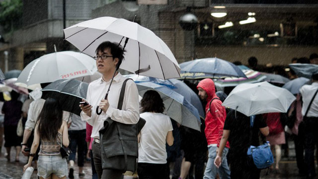 TYPHOON VICENTE. A pedestrian holding an umbrella walks past a subway station flocked with people trying to head home as strong winds and rain are brought by Typhoon Vicente in Hong Kong on July 23, 2012. AFP PHOTO / Philippe Lopez