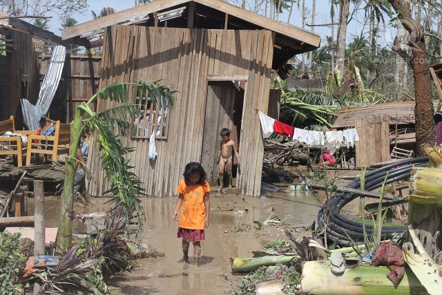Children infront of their damaged home in New Bataan, Compostela Valley, December 5, 2012. Photo by Karlos Manlupig.