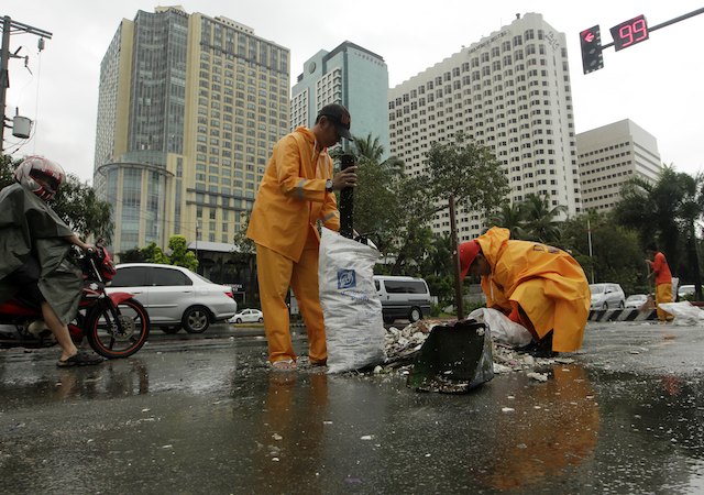 CLEANUP. Workers clear debris brought about Typhoon Santi (Nari) at a street in Manila, Philippines, 12 October 2013. EPA/Francis Malasig