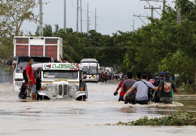 PASSING THROUGH. A passenger jeep maneuvers on a flooded road in the town of San Ildefonso, Bulacan province, Philippines, 12 October 2013. EPA/Dennis Sabangan