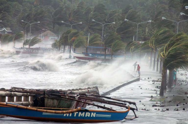 BIG WAVES. Residents stand along a sea wall as high waves pounded them amidst strong winds as Typhoon Haiyan hit the city of Legaspi, Albay. AFP PHOTO/CHARISM SAYAT