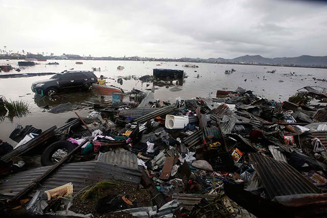 DEVASTATION. A man searches for belongings washed ashore by the typhoon that devastated the city of Tacloban. Photo by EPA/Dennis Sabangan