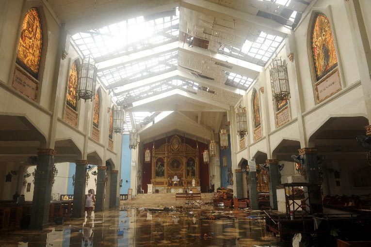 TYPHOON SHELTER. The Sto. Nino church has become a sanctuary for a devout, traumatized community. Photo by Noel Celis/AFP