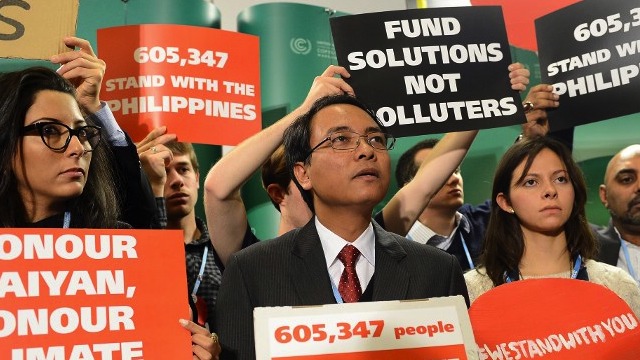 PROTEST IN WARSAW. In this photo, the Philippines' head negotiator Naderev Sano (center) and supporters hold banners while attending the United Nations Climate Change Conference COP 19 on November 19, 2013 in Warsaw. Photo by AFP/Janek Skarzynski