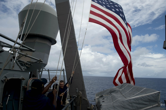 DISPUTED WATERS. US Navy personnel raise their flag during the bilateral maritime exercise between the Philippine Navy and US Navy dubbed Cooperation Afloat Readiness and Training (CARAT 2014) aboard the USS John S. McCain in the South China Sea near waters claimed by Beijing on June 28, 2014. Photo by Noel Celis/Pool/EPA